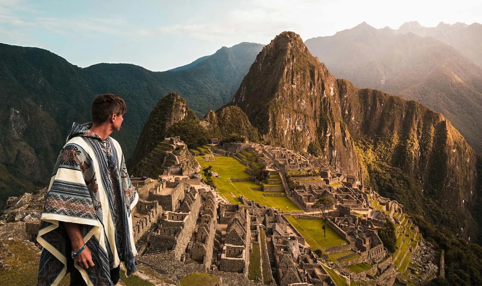 Turista observando la ciudadela de Machu Picchu en altura. 