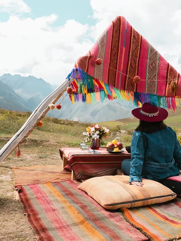 Viajera disfrutando de un picnic andino con vista a las montañas de Cusco