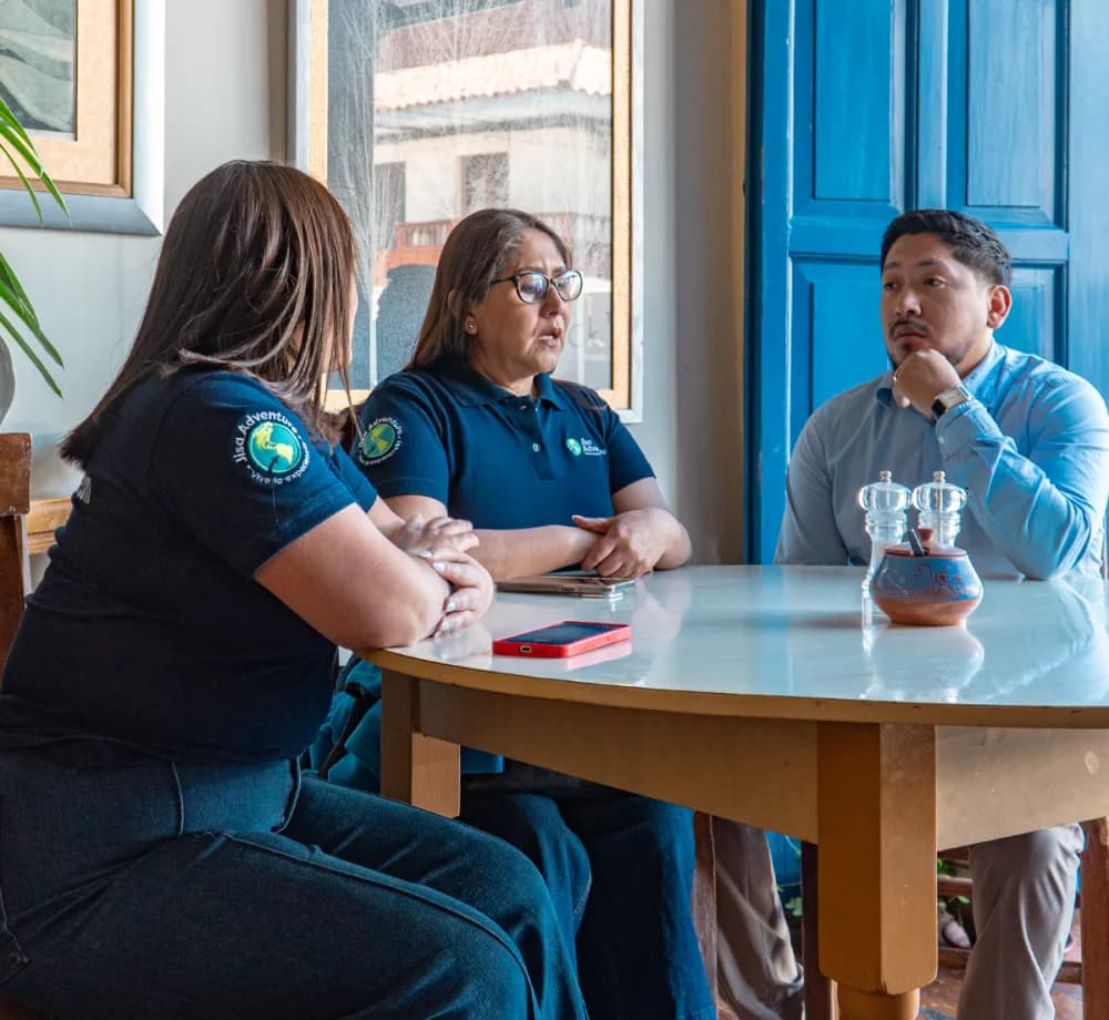 Equipo de Jisa Adventure reunido alrededor de una mesa en una oficina de Cusco