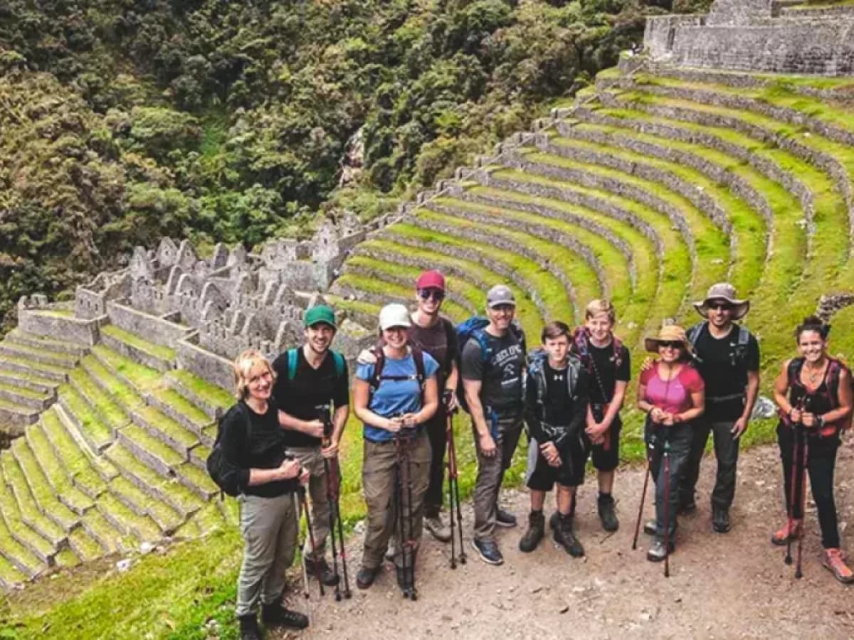 Grupo de viajeros en ruta de senderismo junto a terrazas incas en el camino inca
