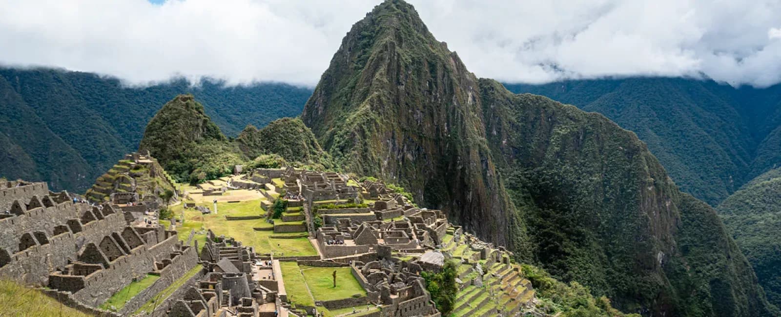 Vista de la ciudadela de Machu Picchu con Huayna Picchu y montañas nubladas