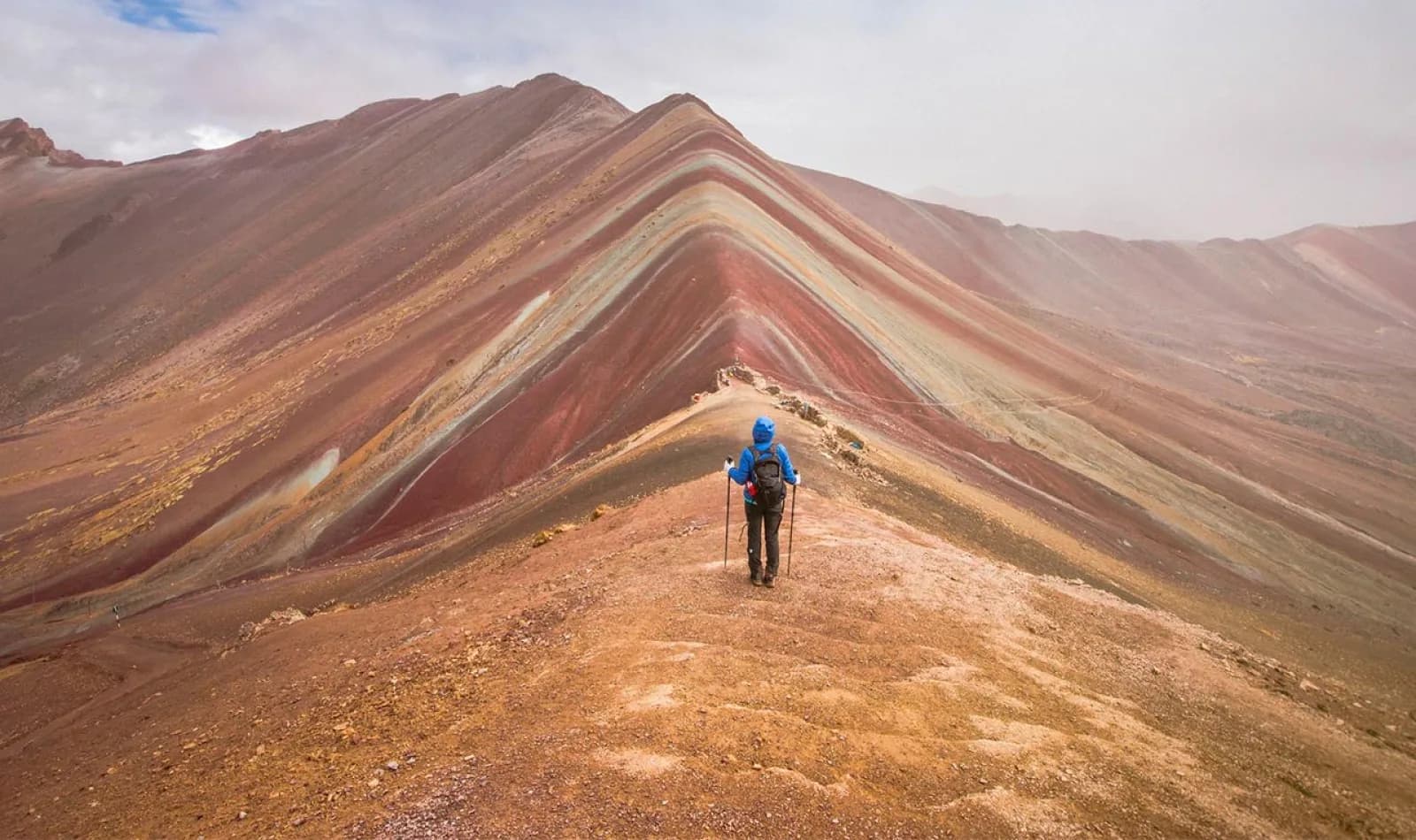 Senderista en la Montaña de Colores (Vinicunca) en Cusco, comparando la altura de Machu Picchu con la altitud de esta cumbre.