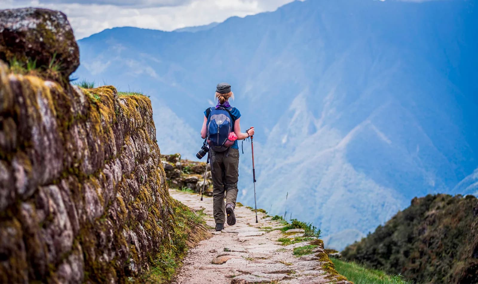 Senderista con bastones de trekking en el Camino Inca rumbo a Machu Picchu.