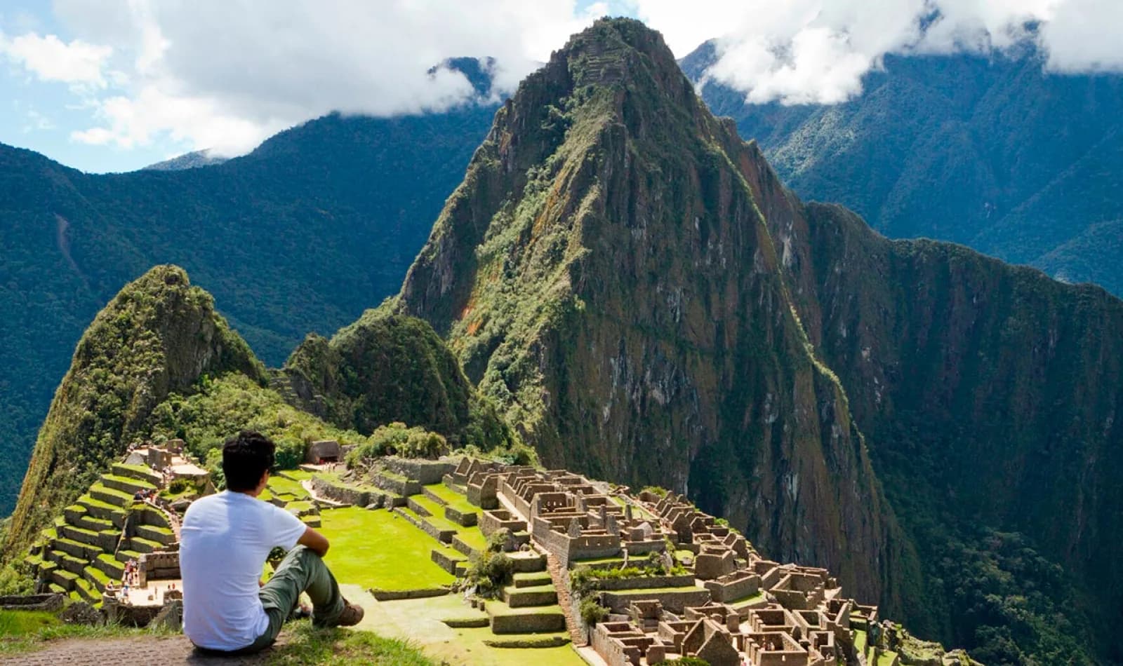 Viajero sentado observando la ciudadela de Machu Picchu