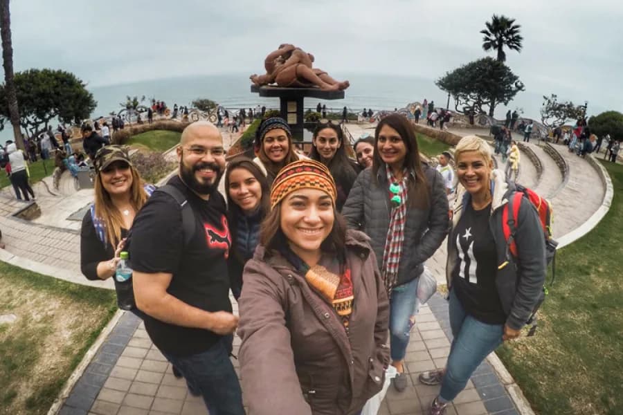 Grupo de viajeros en el Parque del Amor de Miraflores, con la escultura El Beso al fondo