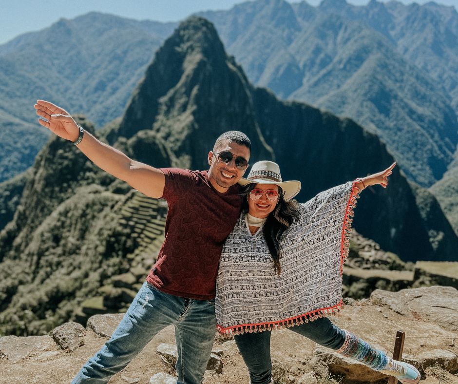 Dos viajeros disfrutando de la impresionante vista de Machu Picchu, Perú."